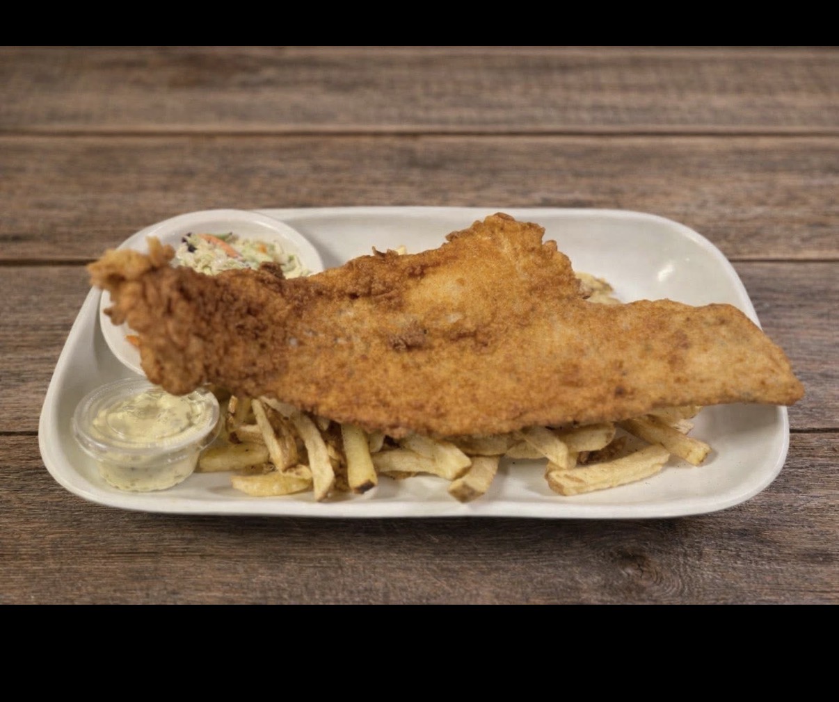 Golden fried fish served over hand-cut fries with coleslaw and tartar sauce