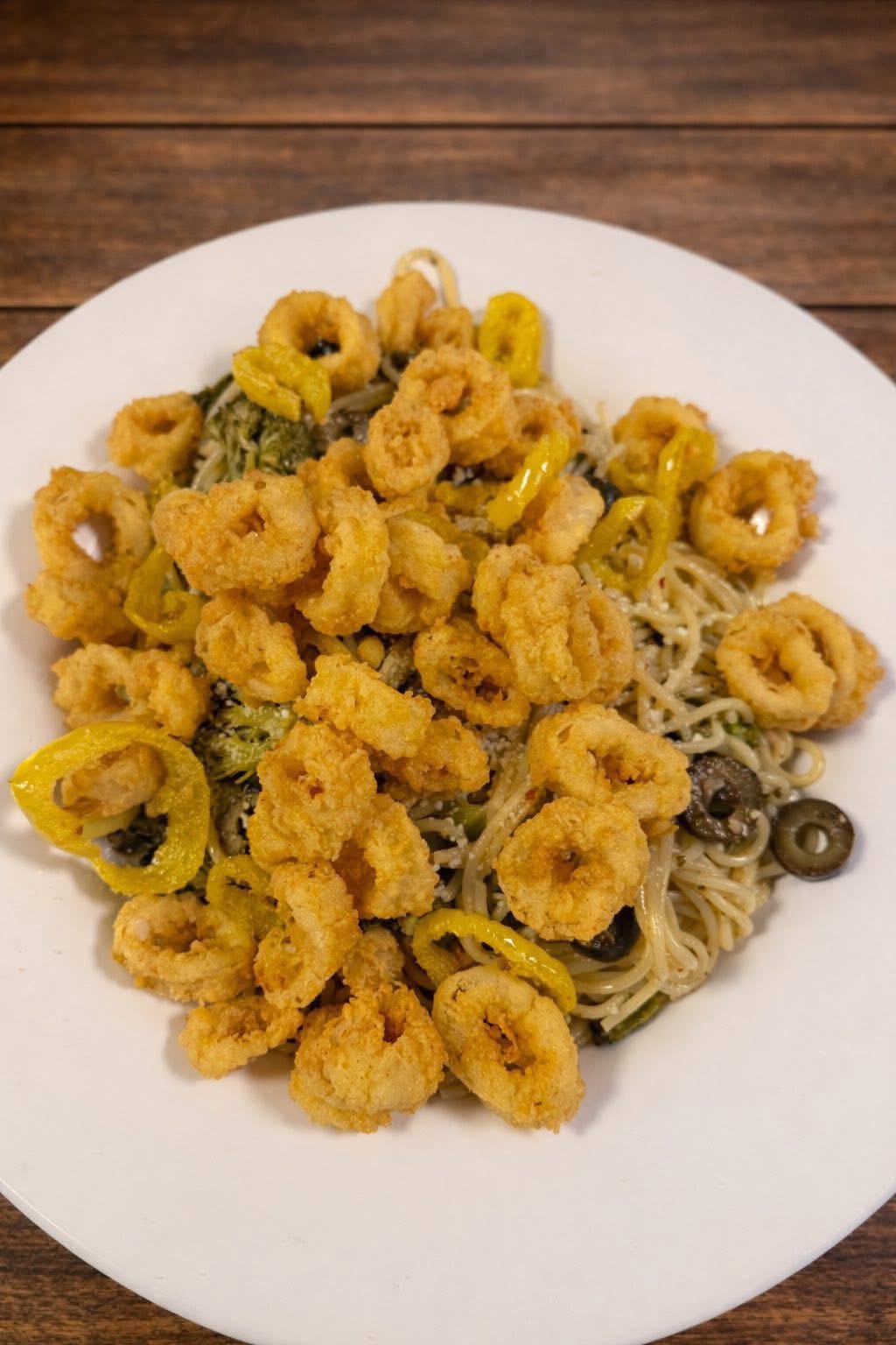 Mediterranean calamari pasta with broccoli, olives and banana peppers